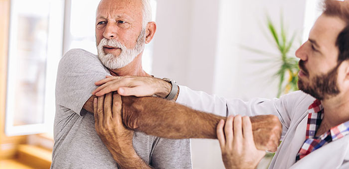 Elderly man receiving shoulder adjustment from Boise chiropractor