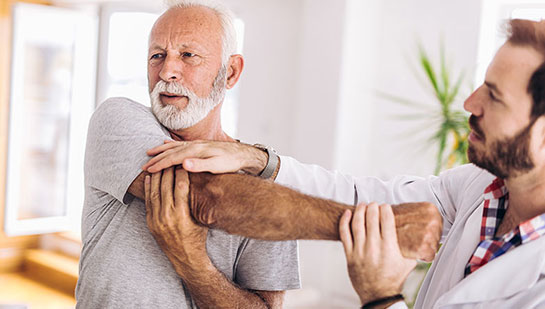 Elderly man receiving shoulder adjustment from Boise chiropractor